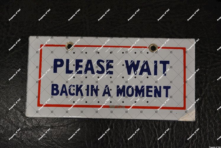 Please Wait Back in a Moment" sign"