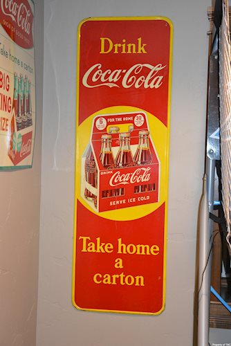 Drink Coca-Cola w/six pack Take Home a Carton" sign"